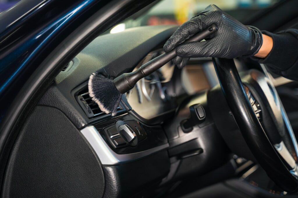 Cleaning car vent with brush. Auto detailing concept